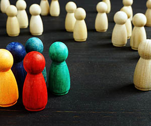 Wooden figures of different colors representing racism in the workplace